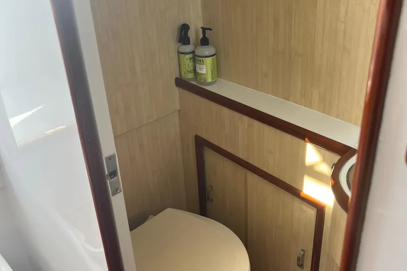Slide: The Image of 1985 Rybovich Walkaround boat bathroom with wooden paneling and toiletries. - 11