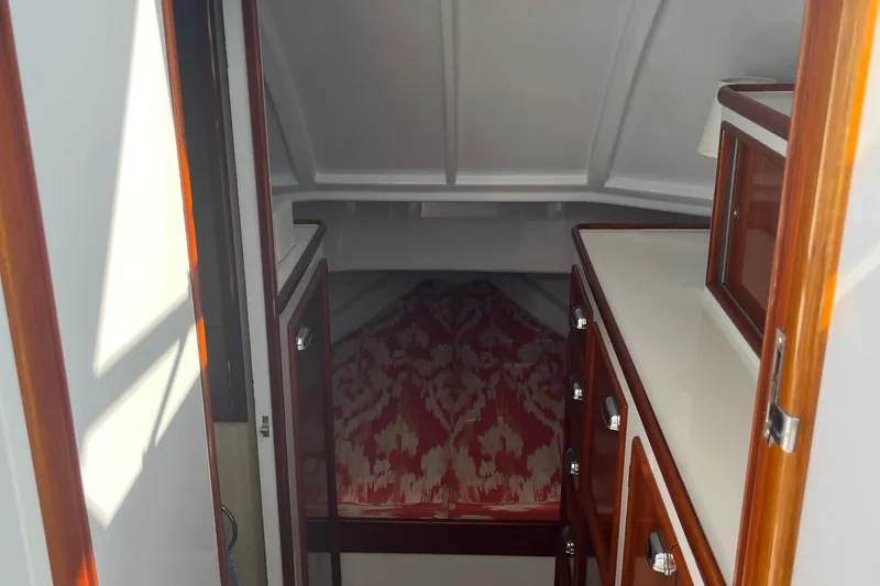 Slide: The Image of 1985 Rybovich Walkaround cabin interior with wood cabinetry and patterned bedding. - 12