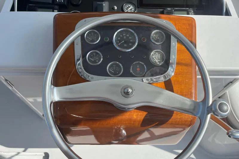 Slide: The Image of 1985 Rybovich Walkaround boat steering wheel and dashboard. - 13