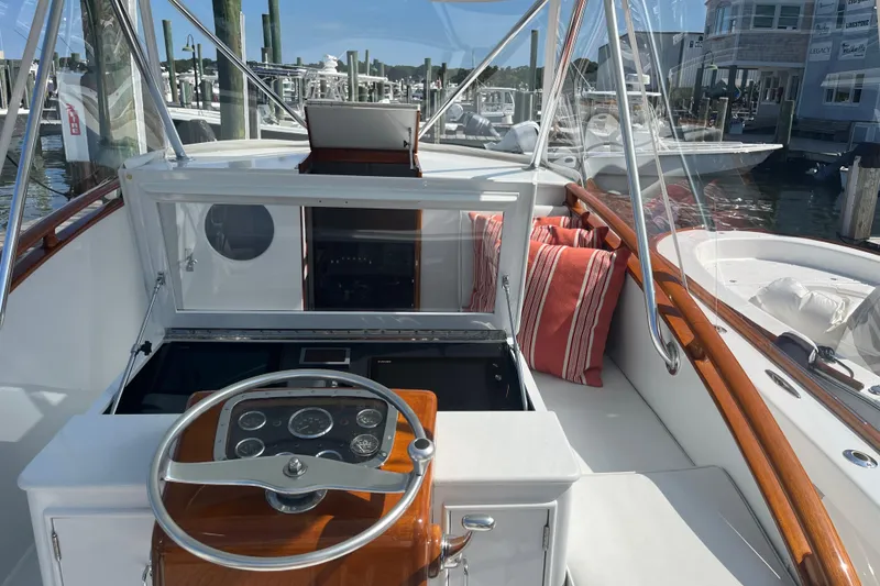 Slide: The Image of 1985 Rybovich Walkaround boat cockpit with steering wheel and marina view. - 15
