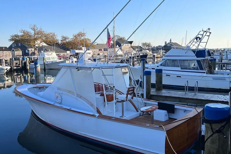 Slide: The Image of 1985 Rybovich Walkaround boat docked at a marina with other boats. - 2
