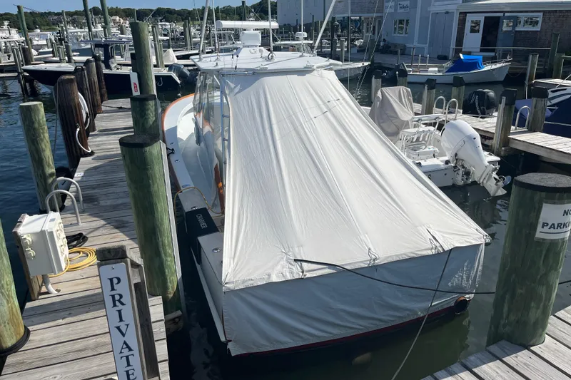 Slide: The Image of 1985 Rybovich Walkaround boat docked at a private marina with cover. - 8