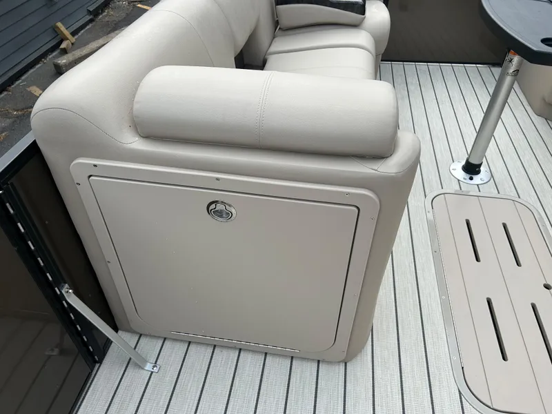 Slide: The Image of 2023 SunCatcher Fusion 324RC boat interior with beige seating and storage compartment. - 12