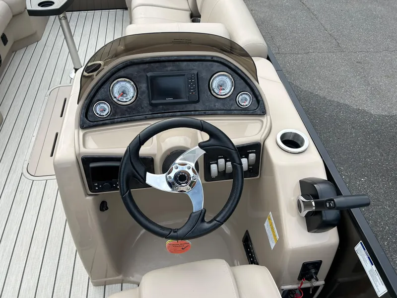 Slide: The Image of 2023 SunCatcher Fusion 324RC boat dashboard with steering wheel and control panel. - 15