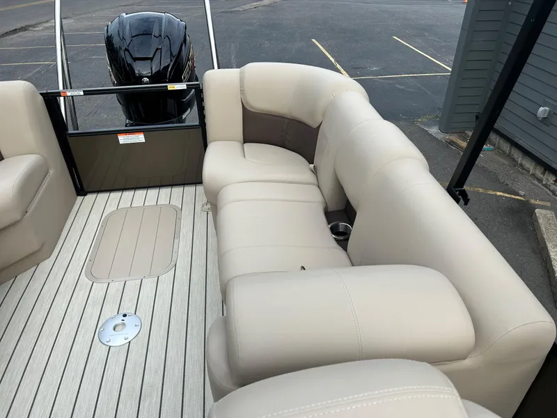 Slide: The Image of 2023 SunCatcher Fusion 324RC boat interior with beige seating and outboard motor. - 18