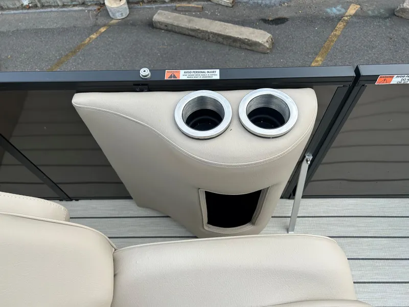 Slide: The Image of SunCatcher Fusion 324RC 2023 boat interior with beige cup holders and storage compartment. - 19
