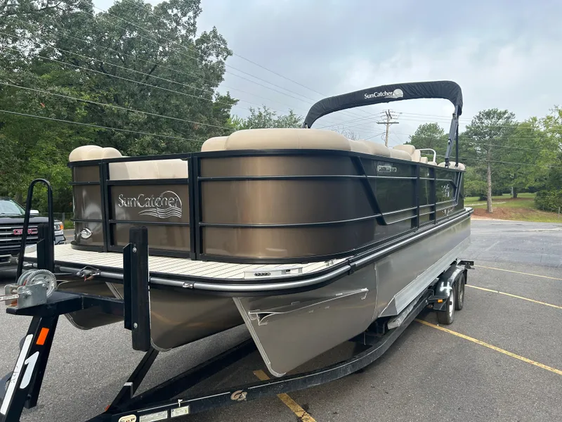 Slide: The Image of 2023 SunCatcher Fusion 324RC pontoon boat on a trailer in a parking lot. - 4
