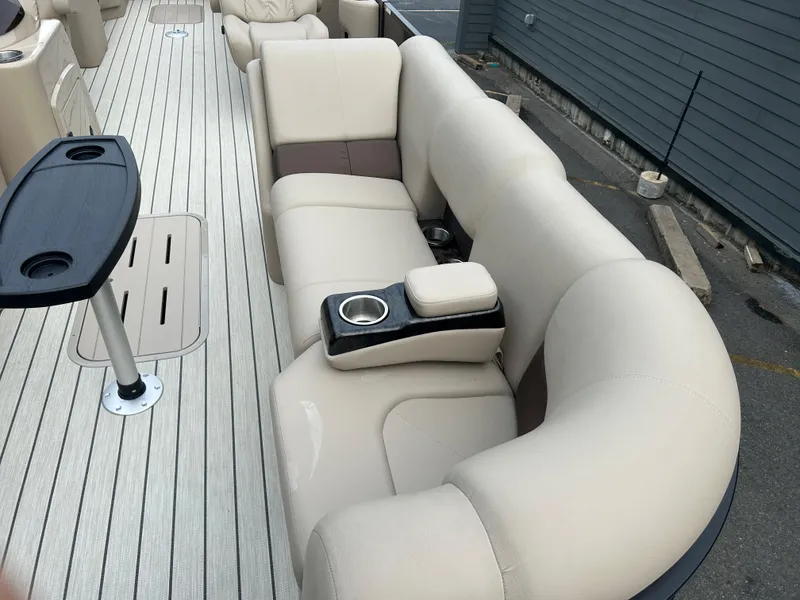 Slide: The Image of 2023 SunCatcher Fusion 324RC boat interior with beige seating and cup holders. - 9