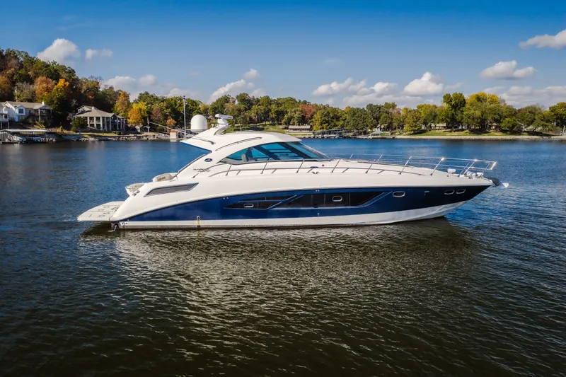The Image of 2013 Sea Ray Sundancer 540 yacht cruising on a scenic lake under a clear blue sky. - 0