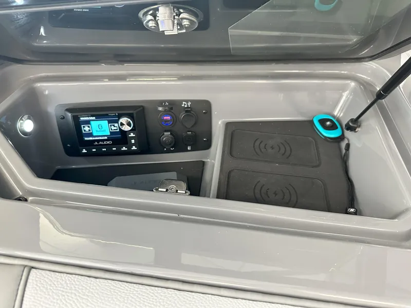 Slide: The Image of 2024 Nautique S23 boat dashboard with JL Audio system and wireless charging pads. - 11