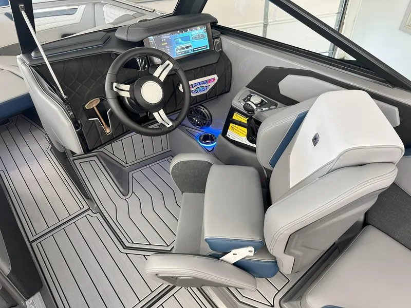 Slide: The Image of 2024 Nautique S23 boat interior with modern dashboard and captain's chair. - 14