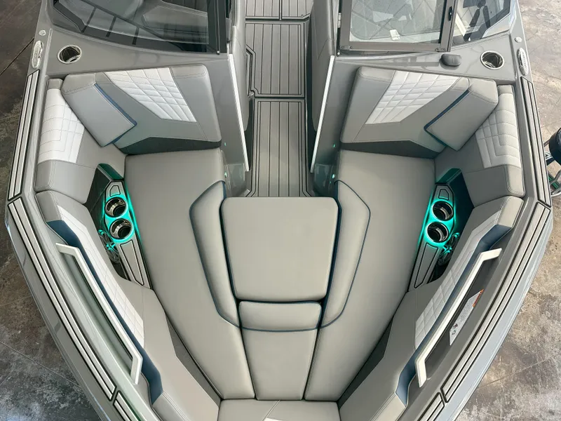Slide: The Image of 2024 Nautique S23 boat interior with gray seating and teal cup holders. - 20