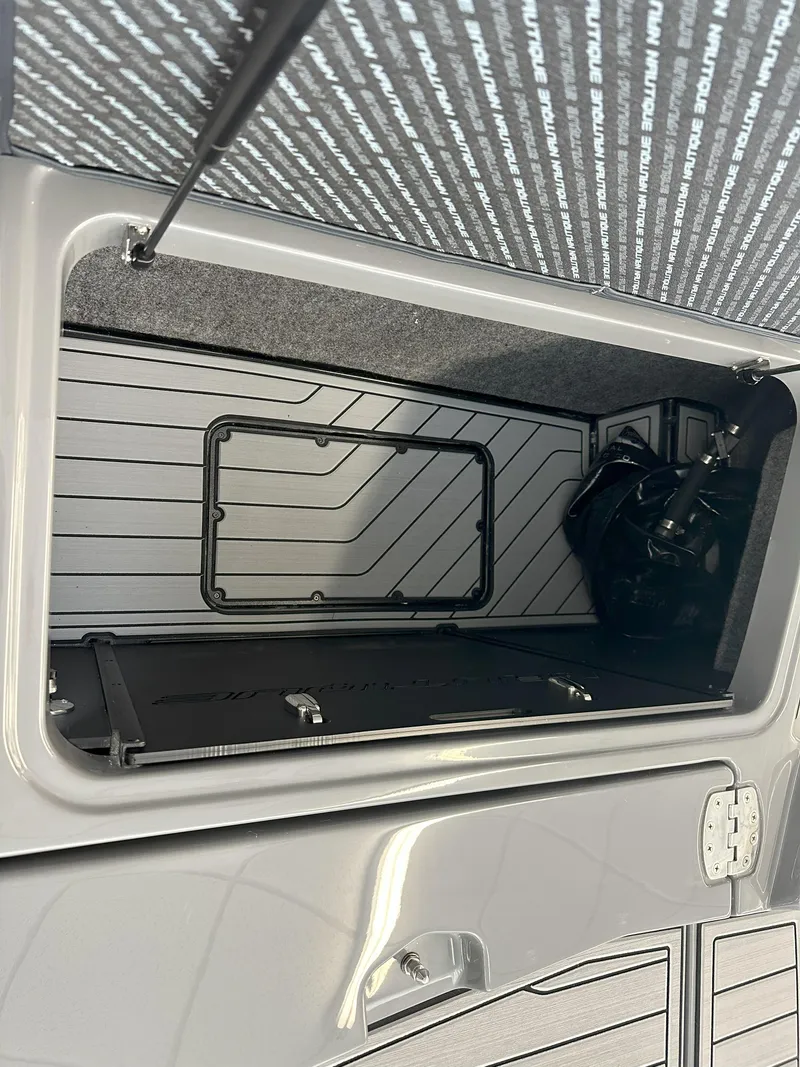 Slide: The Image of 2024 Nautique S23 storage compartment with open hatch. - 22