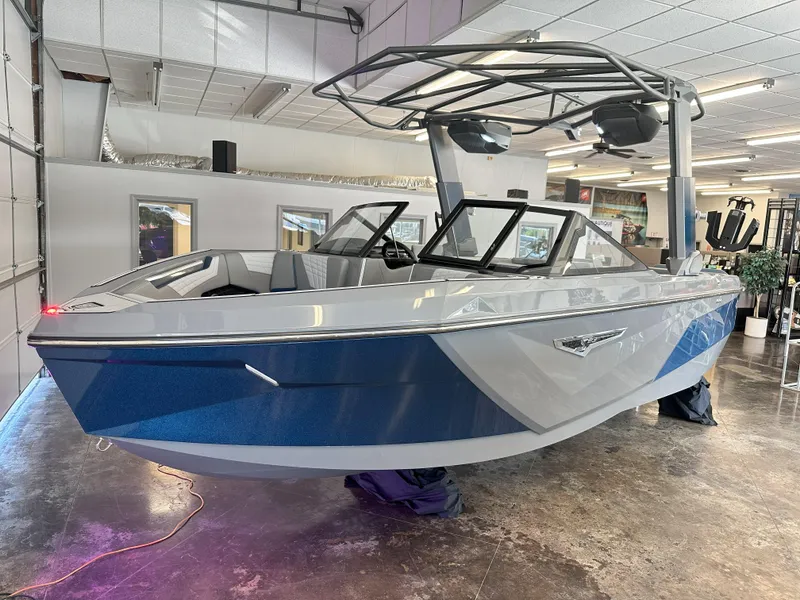 Slide: The Image of 2024 Nautique S23 boat in showroom, blue and white exterior, modern design. - 8
