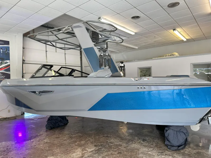 Slide: The Image of 2024 Nautique S23 boat in showroom, featuring sleek blue and gray design. - 9