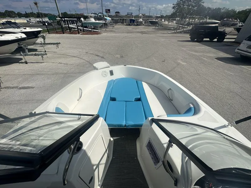 Slide: The Image of 2024 Bayliner Element E21 boat with blue and white seating, docked at a marina. - 17