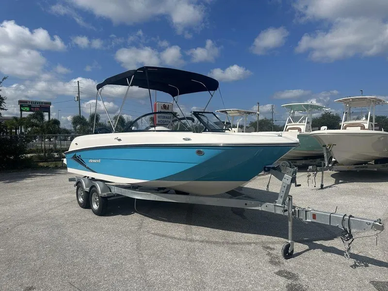 Slide: The Image of 2024 Bayliner Element E21 boat on a trailer under a blue sky. - 22