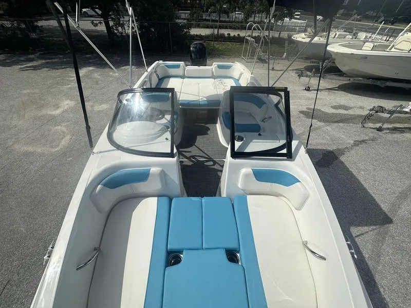 Slide: The Image of 2024 Bayliner Element E21 boat with blue and white interior, docked on land. - 4