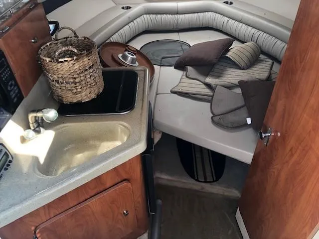 Slide: The Image of 2008 Glastron GS 259 boat interior with kitchenette and cozy sleeping area. - 11