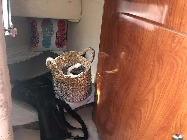 Slide: The Image of Interior cabin of a 2008 Glastron GS 259 boat with woven basket and flip-flop pillow. - 13