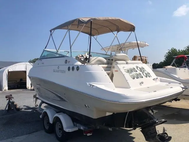 Slide: The Image of 2008 Glastron GS 259 boat on trailer with canopy in marina. - 2