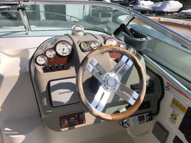 Slide: The Image of 2008 Glastron GS 259 boat dashboard with Garmin GPS and wooden steering wheel. - 7