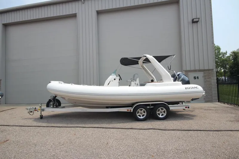 The Image of 2024 Zodiac Medline 7.5 NEO 300hp boat on a trailer outside a warehouse. - 1