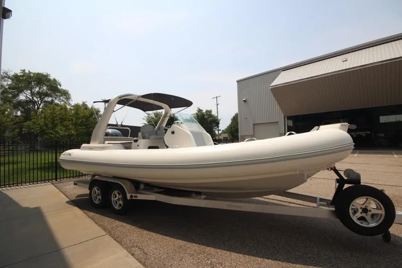 Slide: The Image of 2024 Zodiac Medline 7.5 NEO 300hp boat on trailer outside a warehouse. - 3