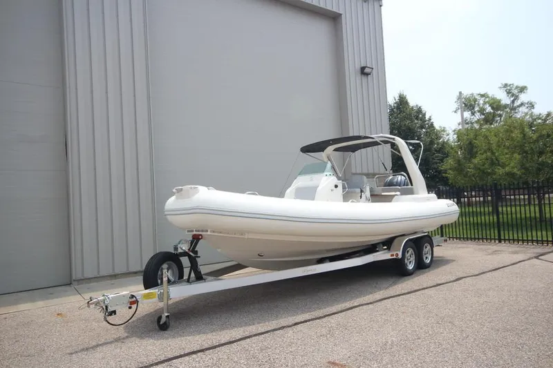 Slide: The Image of 2024 Zodiac Medline 7.5 NEO 300hp boat on trailer, parked outside a building. - 32