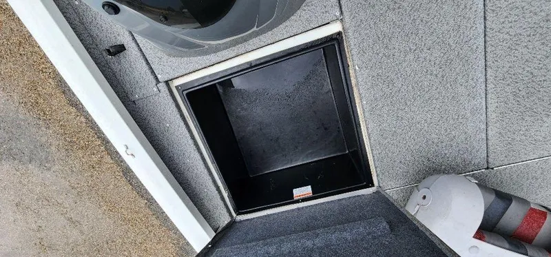 Slide: The Image of 2022 G3 Sportsman 1710 boat storage compartment with gray carpeted flooring. - 21