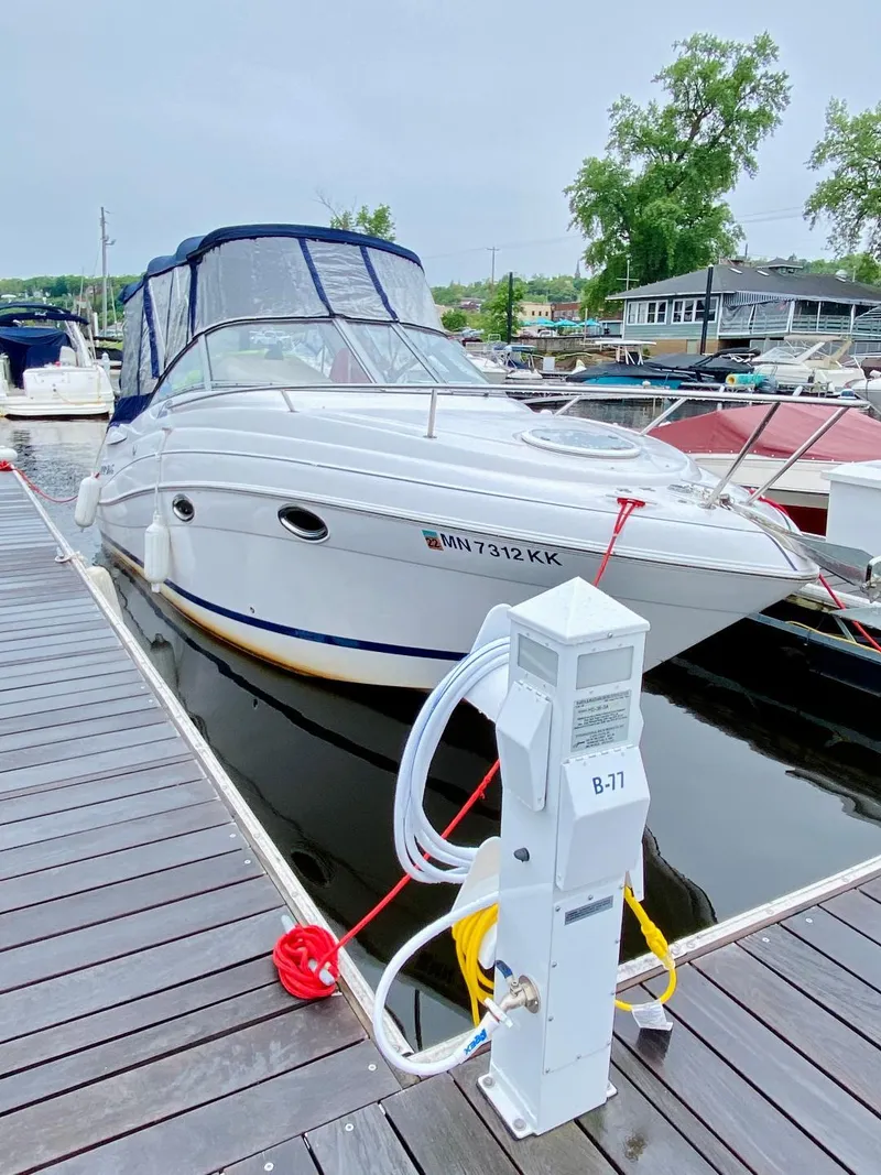 The Image of 2007 Four Winns Vista 258 boat docked at marina with power hookup. - 1