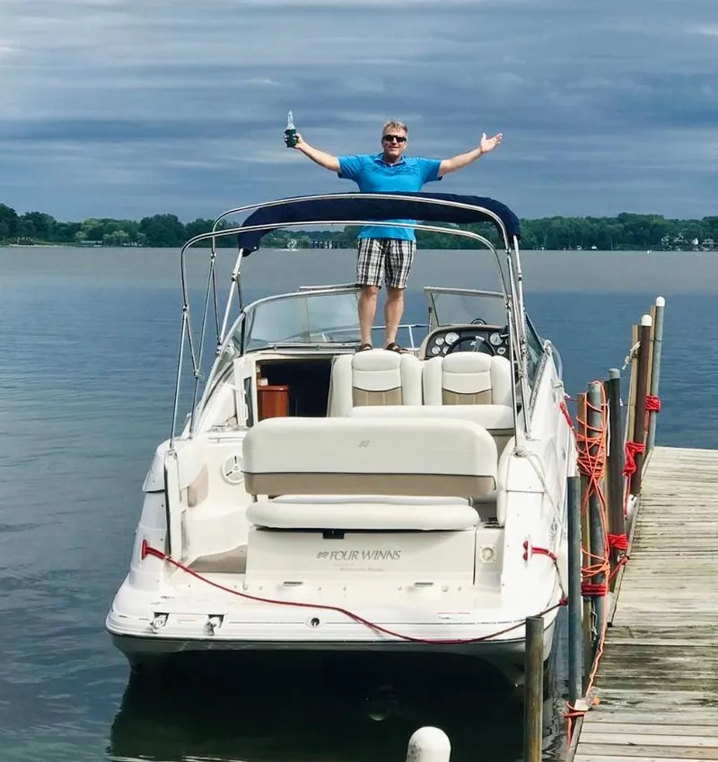 Slide: The Image of Man celebrating on 2007 Four Winns Vista 258 boat docked by a lake. - 4