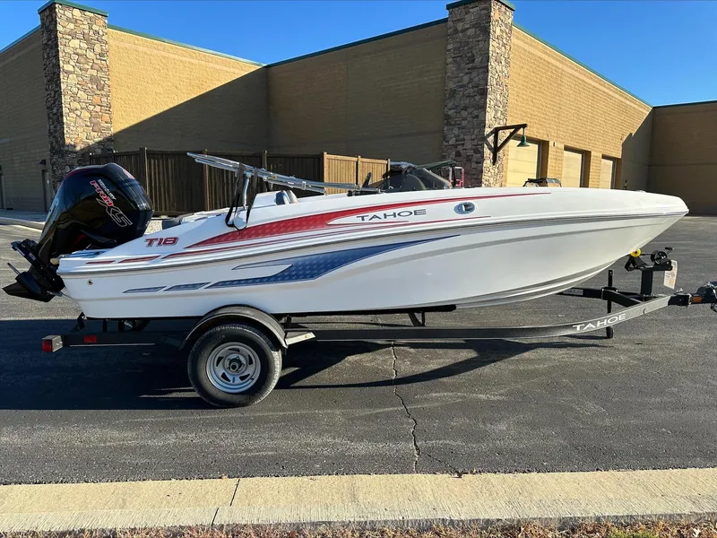 Slide: The Image of 2024 Tahoe T18 boat on trailer, parked outdoors. - 2