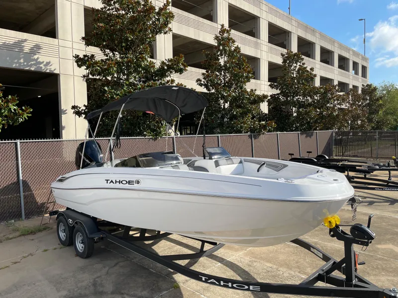 Slide: The Image of 2024 Tahoe T21 boat on a trailer, parked near a building. - 3