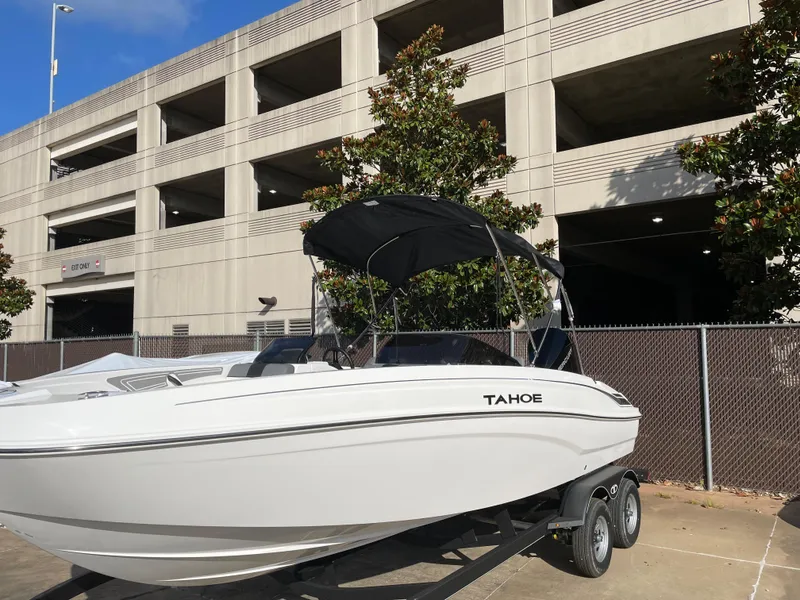 Slide: The Image of 2024 Tahoe T21 boat on trailer near a parking structure. - 4