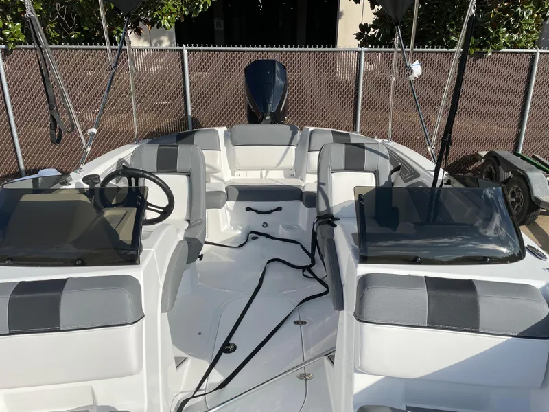 Slide: The Image of 2024 Tahoe T21 boat interior with gray and white seating, steering wheel, and windshield. - 6