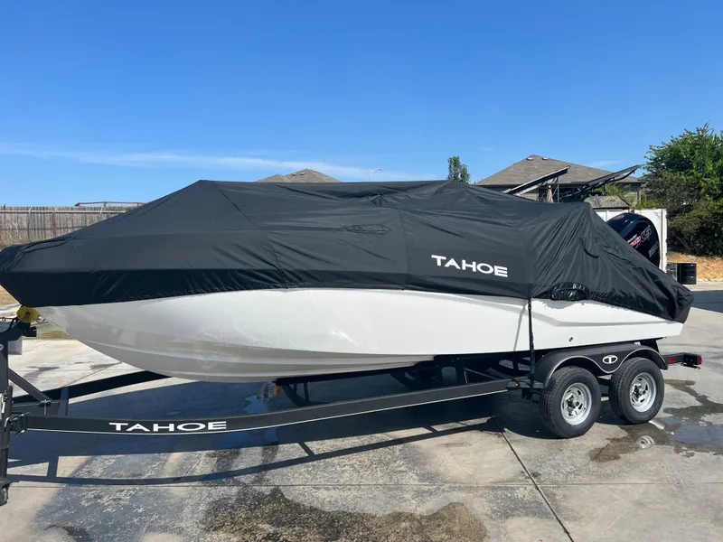 Slide: The Image of 2024 Tahoe T21 boat with cover on trailer in driveway. - 10