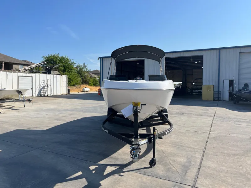 Slide: The Image of 2024 Tahoe T21 boat on trailer in front of a storage facility. - 2