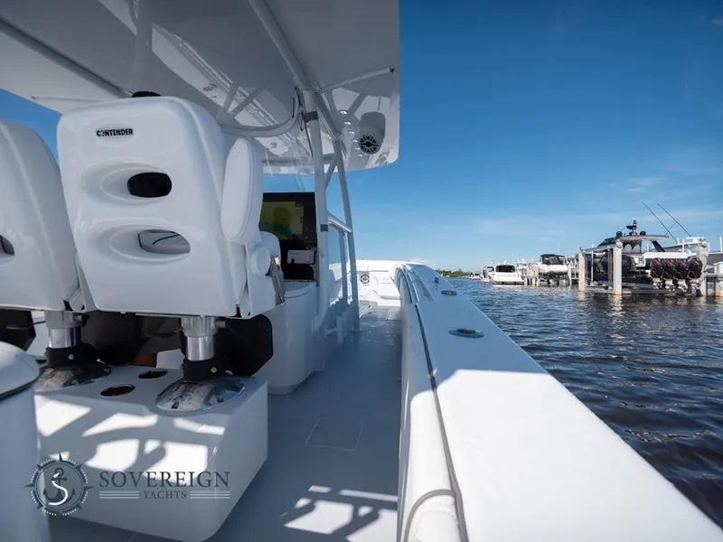 Slide: The Image of 2024 Contender 44 CB yacht interior with white seating, docked at marina. - 21