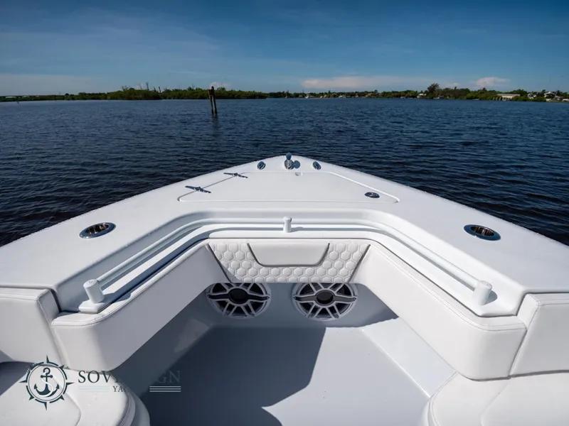 Slide: The Image of 2024 Contender 44 CB boat bow with seating and speakers on a calm lake. - 32