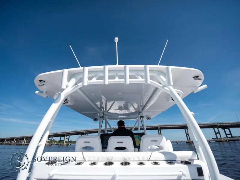 Slide: The Image of 2024 Contender 44 CB boat on water, viewed from the rear, with bridge in background. - 34