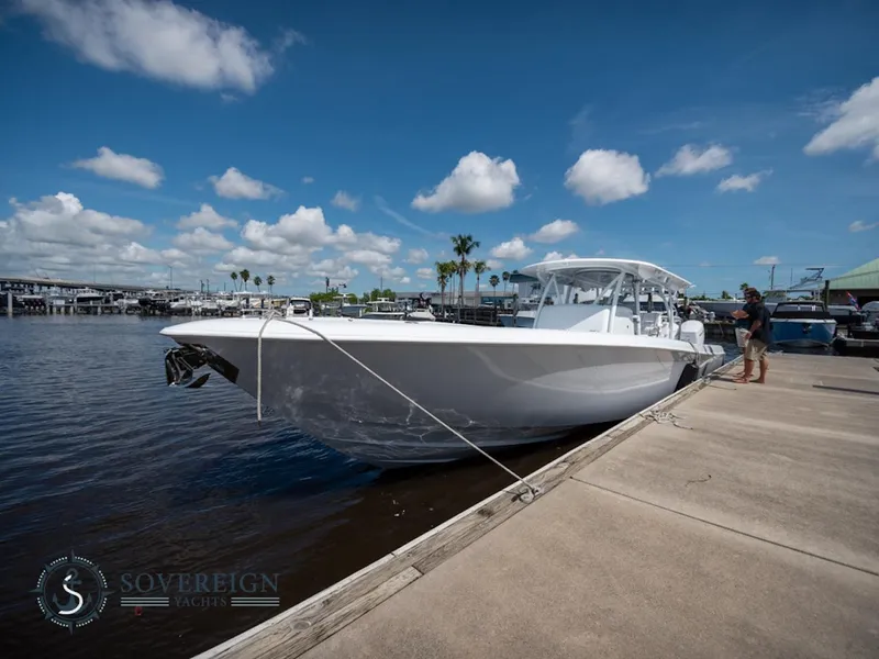 Slide: The Image of 2024 Contender 44 CB boat docked at a marina under a clear blue sky. - 38