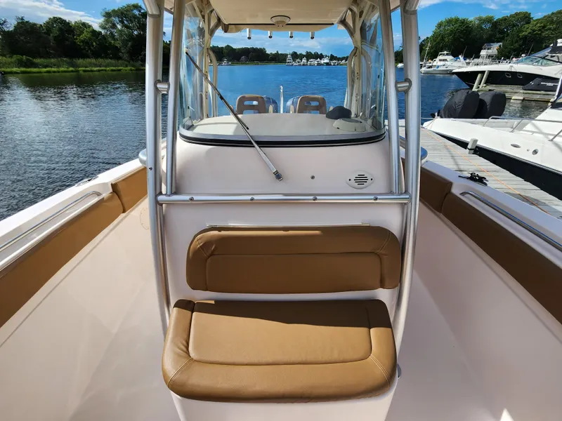 Slide: The Image of 2008 Grady-White 306 Bimini CC boat interior with tan seating, docked by the water. - 11