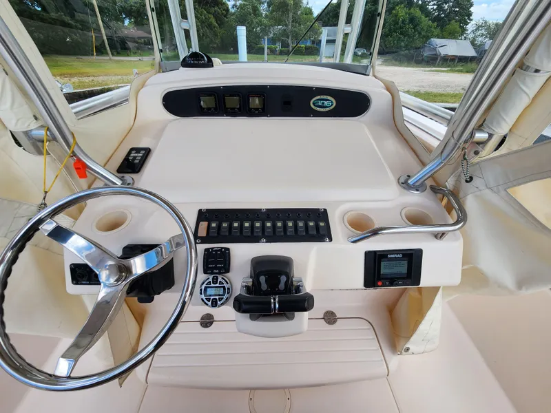 Slide: The Image of 2008 Grady-White 306 Bimini CC boat helm with steering wheel and control panel. - 7