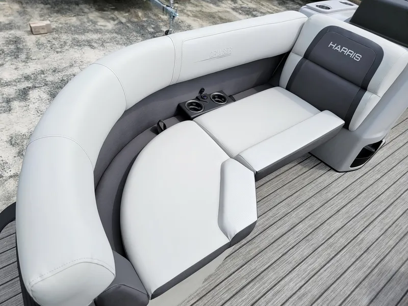 Slide: The Image of 2024 Harris Cruiser 210 boat seating with cup holders and grey upholstery. - 11