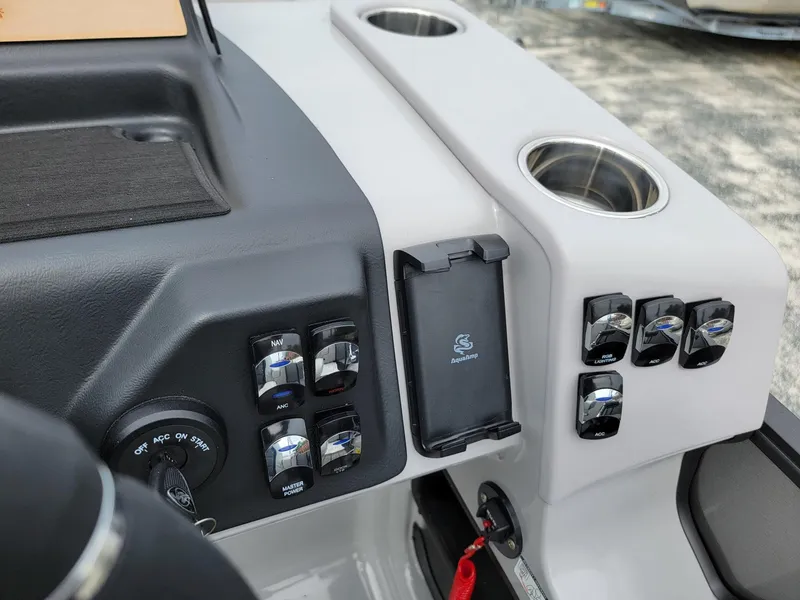 Slide: The Image of Control panel of 2024 Harris Cruiser 210 boat with switches and cup holders. - 17
