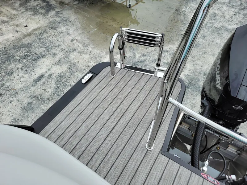 Slide: The Image of 2024 Harris Cruiser 210 boat deck with ladder and Mercury engine. - 24