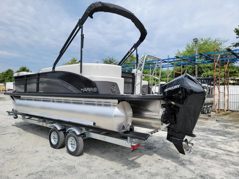 Slide: The Image of 2024 Harris Cruiser 210 pontoon boat on a trailer with a Mercury outboard motor. - 3