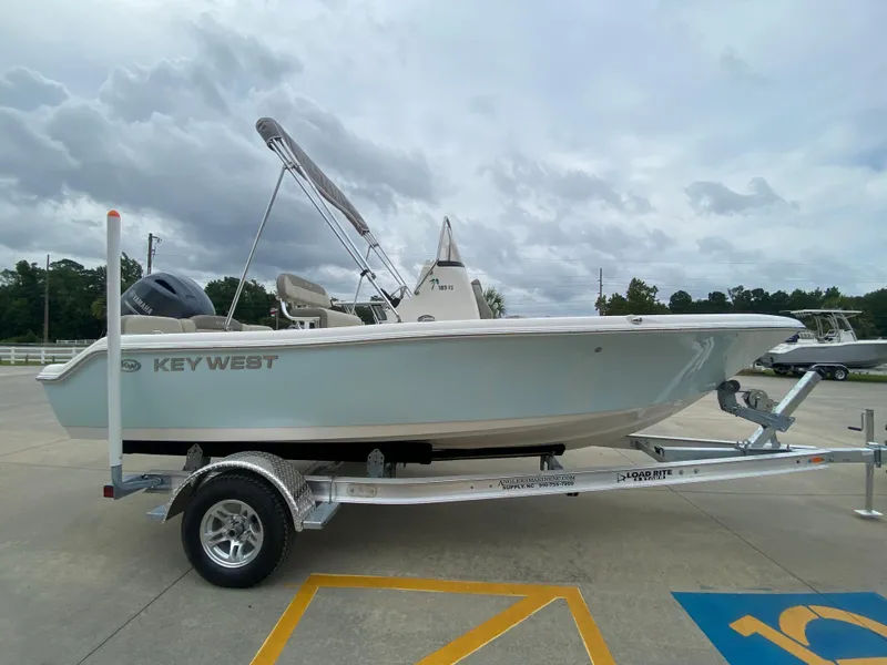 Slide: The Image of 2024 Key West 189 FS boat on a trailer in a parking lot. - 2