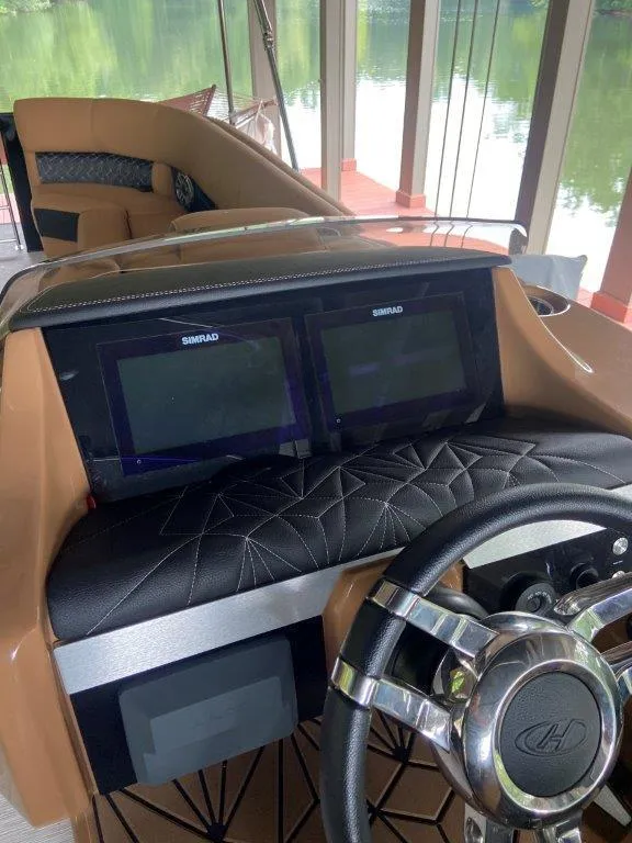 Slide: The Image of 2023 Harris FloteBote 250 Grand Mariner dashboard with dual Simrad displays and luxury seating. - 14